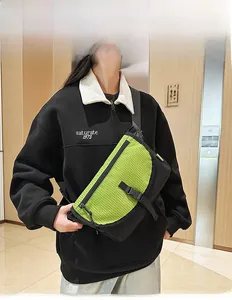 Borsa a tracolla verde neon con rete nera e fibbia a scatto su modello maschile