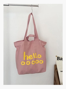 Detailweergave van de roze canvas shopper met gele artistieke hello ooooo letters