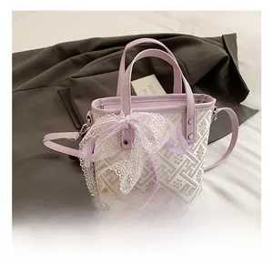 Close-up of mini purple bucket bag featuring floral jacquard and a large lace bow detail