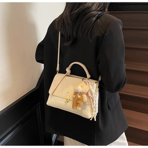 Beige Umhängetasche mit gewebter Textur, Bärenanhänger und elegantem Seidenschal-Dekor am Griff