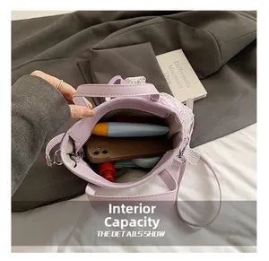 Detail showing internal capacity of light purple lace bucket bag with phone and sunblock