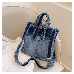 Détails rapprochés des bords effilochés et du tissu denim bleu délavé du sac cabas
