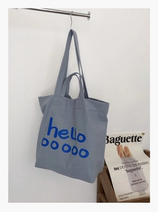 Detail van grijze canvas shopper met blauwe hello ooooo print en dubbele handvatten