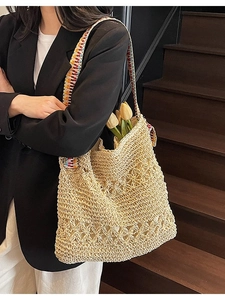 Handmade straw shoulder bag with floral hollow pattern and colorful ethnic strap