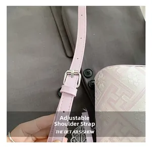 Detail of adjustable light pink leather strap with silver buckle on jacquard bucket bag