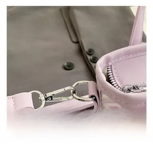 Macro shot of silver metal hook and lavender leather edging on a patterned bucket bag