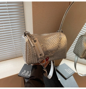 Detail of silver woven cylinder bag featuring metallic texture and fashion zip
