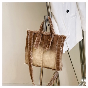 Détail du sac cabas en jean avec dégradé marron et bords à franges vintage