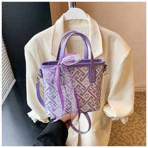 Close-up of vintage bucket bag with purple geometric patterns and white lace bow detail