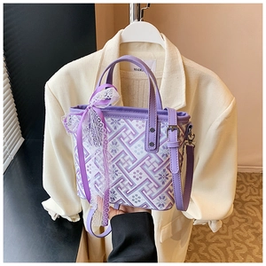 Detail of purple geometric fabric tote bag with a lace bow and adjustable shoulder strap