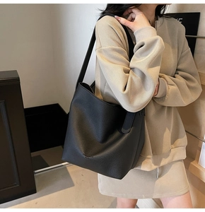 Détail du cuir grainé noir de haute qualité et logo embossé sur ce sac seau élégant