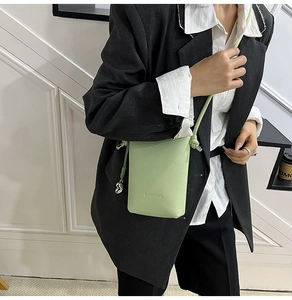 Dettaglio della mini borsa a tracolla in pelle martellata verde chiaro con logo