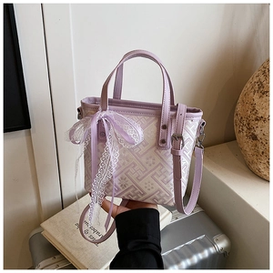 Detail of lavender jacquard bucket bag featuring lace bow and silver hardware accents