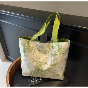 Detailed close-up of a satin tote bag featuring a vibrant green bamboo forest pattern