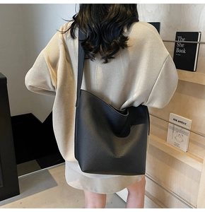 Détail du sac cabas en cuir grainé noir avec un marquage discret Fashion Trend en relief