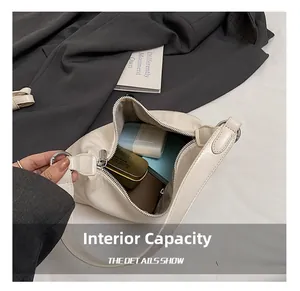 Detail view of the spacious inner compartment of the beige leather shoulder bag
