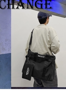 Close-up of black nylon tote bag featuring adjustable strap and branded NOCO print detail