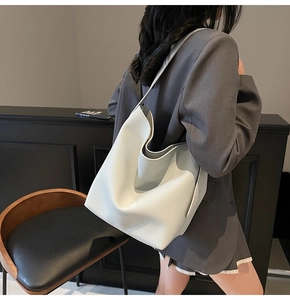 Détail du cuir grainé blanc et logo FASHION TREND sur un grand sac à main style hobo