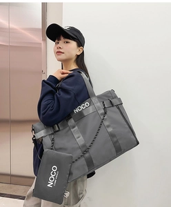 Detail of grey nylon tote bag with small accessory pouch and black webbing shoulder strap