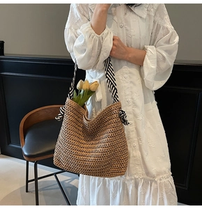 Detail of straw woven tote with black and white striped bow handle and tulip decor