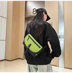 Dettaglio della borsa a tracolla verde neon e nera con trama in nylon a griglia resistente