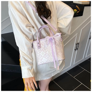 Detail of lavender lace bow and geometric pattern on a stylish crossbody bucket bag