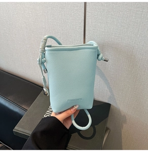 Dettaglio della borsa azzurra con trama litchi e tracolla in corda intrecciata