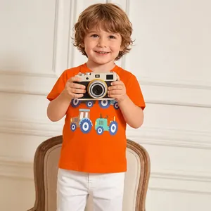 Detail of orange cotton T-shirt featuring a cartoon tractor print on a young boy model