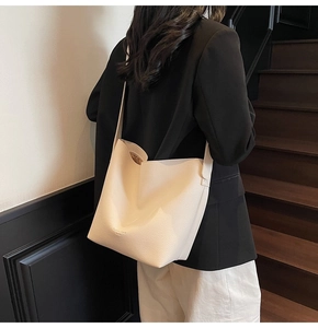 Détail du sac seau blanc crème avec texture en cuir grainé et bandoulière élégante