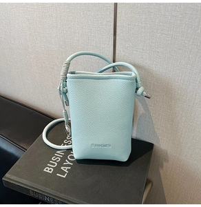 Dettaglio della borsa in pelle azzurra con motivo litchi e logo SUNWOMEN impresso