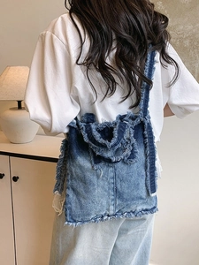 Sac cabas en jean bleu avec bords effilochés dans un décor intérieur minimaliste