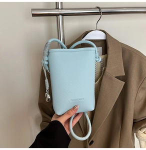 Dettaglio mini borsa in pelle azzurra con tracolla a corda e logo SUNWOMEN