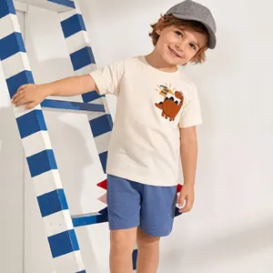 Detail of boys' summer set featuring a monster print cotton t-shirt and blue shorts