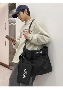 Detail of black nylon tote bag with wide shoulder strap and matching mini pouch bag
