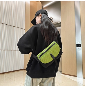 Borsa a tracolla con patta a scacchi verde neon e fibbia indossata da un modello