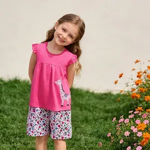 Outdoor girl wearing pink cotton top with giraffe print and floral shorts summer set