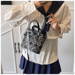 Detail of a retro bucket bag with geometric patterns and a large lace bow accent