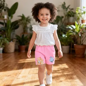 Detail of girls summer set with lace sleeve top and cartoon shorts in a sunlit room