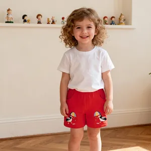 Detail of white cotton T-shirt and red shorts with cute bird embroidery for girls