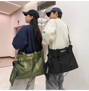 Detail of durable nylon tote bags in green and black with NOCO logo and wide shoulder straps