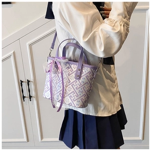 Detail view of purple fabric bucket bag with Chinese floral patterns and lace bow