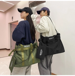 Detail of army green and black nylon tote bags with NOCO logo and adjustable crossbody strap