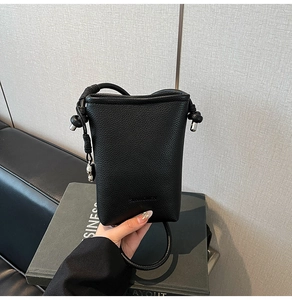 Dettaglio borsa a secchiello in pelle martellata nera con sfere metalliche e tracolla