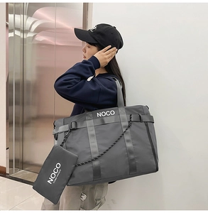 Detail view of large dark grey nylon tote bag with white NOCO branding on shoulder