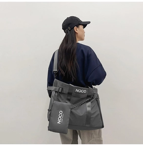 Detail of grey nylon tote bag with detachable mini pouch and adjustable strap