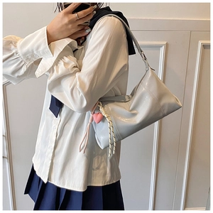 Mirror selfie showing a light blue patent leather underarm bag with pink heart pendant