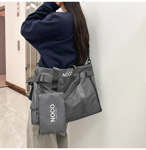 Detail of grey nylon tote bag with white lettering and detachable zippered pouch