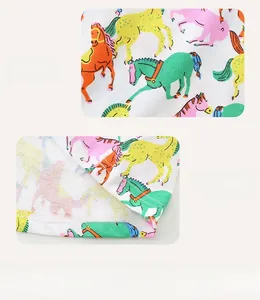 Détail de l'imprimé cheval coloré et des coutures soignées sur la robe d'été blanche fille