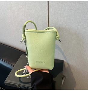 Dettaglio mini borsa a secchiello verde pistacchio con trama lychee e logo SUNWOMEN