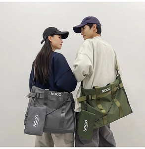 Detail of grey and green waterproof nylon tote bag with side buckles and small pouch
